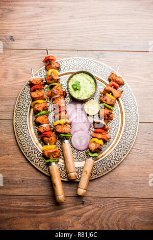 Chicken Tikka/skew Kebab. Traditionelle indische Gericht gekocht auf Holzkohle und Flamme, gewürzt & bunt garniert. Mit grüner Chutney und Salat serviert. Stockfoto