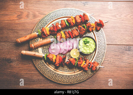 Chicken Tikka/skew Kebab. Traditionelle indische Gericht gekocht auf Holzkohle und Flamme, gewürzt & bunt garniert. Mit grüner Chutney und Salat serviert. Stockfoto