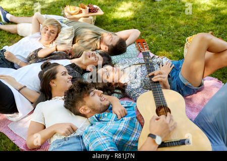 Freunde Gitarre spielen und Chillen im Park Stockfoto