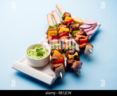Chicken Tikka/skew Kebab. Traditionelle indische Gericht gekocht auf Holzkohle und Flamme, gewürzt & bunt garniert. Mit grüner Chutney und Salat serviert. Stockfoto