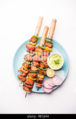 Chicken Tikka/skew Kebab. Traditionelle indische Gericht gekocht auf Holzkohle und Flamme, gewürzt & bunt garniert. Mit grüner Chutney und Salat serviert. Stockfoto
