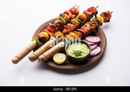 Chicken Tikka/skew Kebab. Traditionelle indische Gericht gekocht auf Holzkohle und Flamme, gewürzt & bunt garniert. Mit grüner Chutney und Salat serviert. Stockfoto