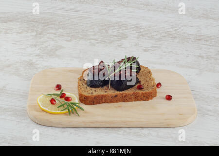 Sandwich mit Roggenbrot in Scheiben geschnitten und Blutwurst auf Holzplatte Stockfoto