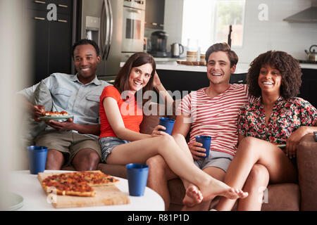 Junge Erwachsene Freunde Fernsehen mit Essen und Trinken zu Hause Stockfoto