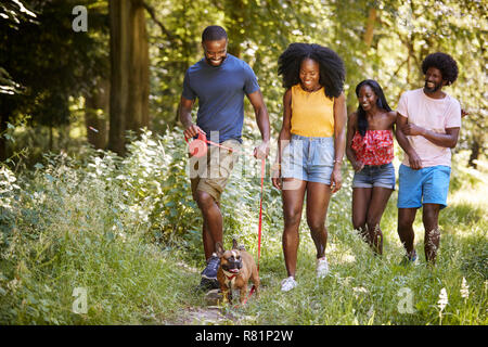 Zwei schwarze Paare Wandern mit Hund in einem Wald Stockfoto