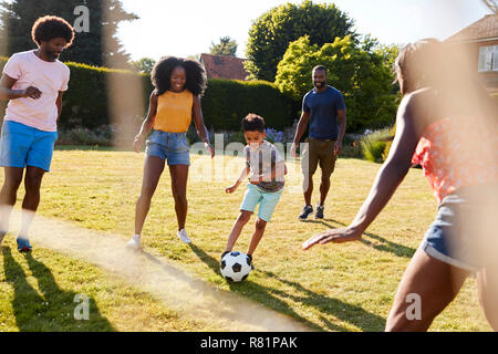 Nach Familie Fußball spielen mit jungen Sohn im Garten Stockfoto