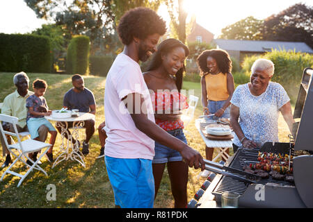 Paar grillen an einem Schwarzen multi Generation Familie Grill Stockfoto