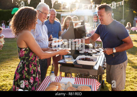 Menschen, die an Grill Abschaltdruck am Sommer Garten Fete Stockfoto