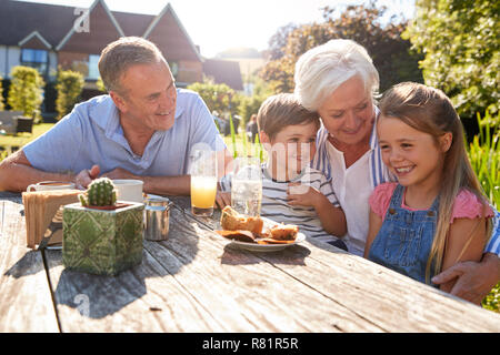 Großeltern mit Enkeln genießen Sie im Sommer einen Snack im Cafe Stockfoto