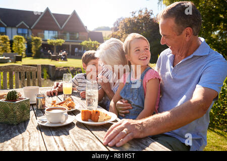 Großeltern mit Enkeln genießen Sie im Sommer einen Snack im Cafe Stockfoto