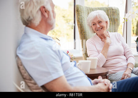 Senior Paar Sitzen auf Stühlen und Chatten im Ruhestand Home Stockfoto