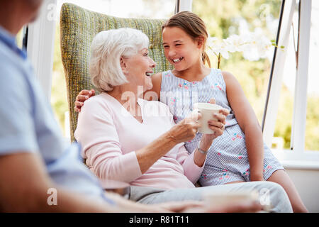 Enkelin Grosseltern zu Besuch in der Lounge des Seniorenheims Stockfoto