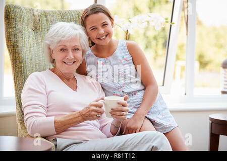 Portrait von Enkelin ihrer Großmutter in der Lounge des Seniorenheims Stockfoto