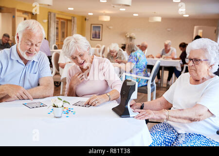 Gruppe von Senioren spielen Spiel von Bingo im Ruhestand Home Stockfoto