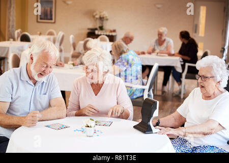 Gruppe von Senioren spielen Spiel von Bingo im Ruhestand Home Stockfoto