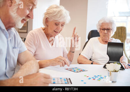 Gruppe von Senioren spielen Spiel von Bingo im Ruhestand Home Stockfoto