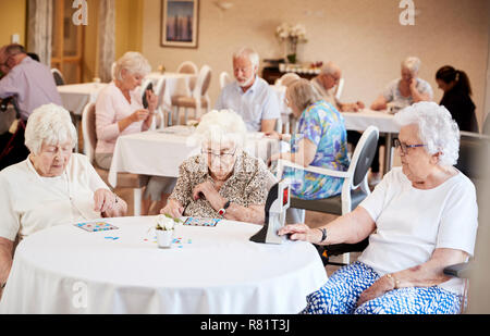 Gruppe von Senioren spielen Spiel von Bingo im Ruhestand Home Stockfoto