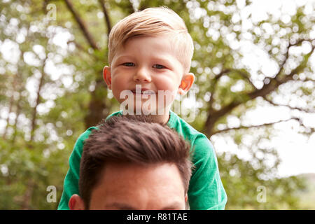 Nahaufnahme von Vater mit Sohn auf den Schultern auf Spaziergang am Fluss Stockfoto