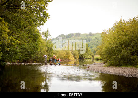 Großeltern mit Enkeln Fluß bei Wanderungen in England Lake District Stockfoto