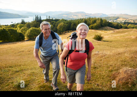Portrait von Senior Paar klettern Hügel auf Wanderung durch die Landschaft im Lake District in Großbritannien Zusammen Stockfoto