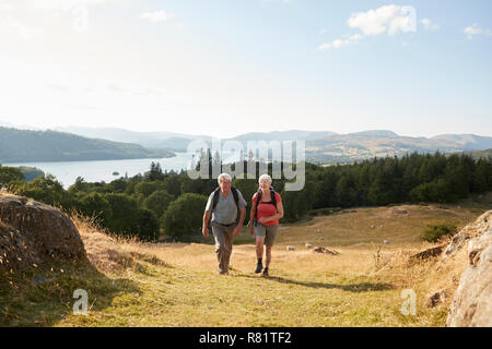 Senior Paar klettern Hügel auf Wanderung durch die Landschaft in Lake District in Großbritannien Stockfoto