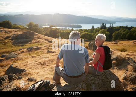 Senior Paar ruhen auf dem Hügel auf der Wanderung durch die Landschaft im Lake District in Großbritannien Stockfoto