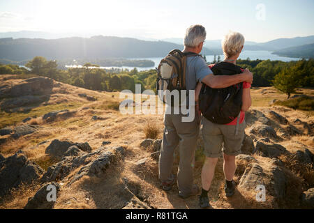 Ansicht der Rückseite des Senior paar stehen an der Spitze der Hügel auf Wanderung durch die Landschaft im Lake District in Großbritannien Stockfoto