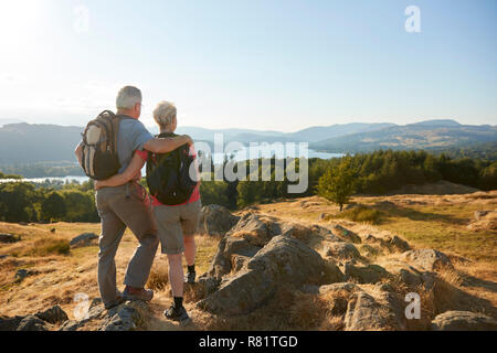 Ansicht der Rückseite des Senior paar stehen an der Spitze der Hügel auf Wanderung durch die Landschaft im Lake District in Großbritannien Stockfoto