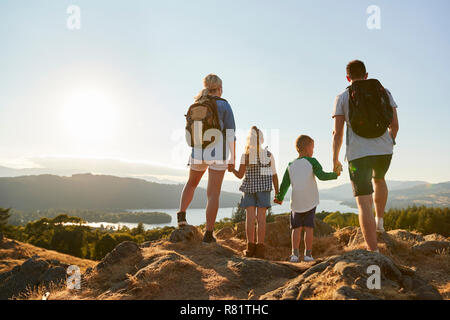 Rückansicht der Familie, die an der Oberseite des Hügels auf Wanderung durch die Landschaft im Lake District in Großbritannien Stockfoto