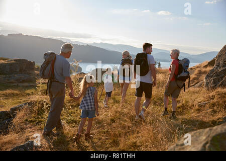 Ansicht der Rückseite des Multi Generation Familie zu Fuß auf dem Hügel auf der Wanderung durch die Landschaft im Lake District in Großbritannien Stockfoto