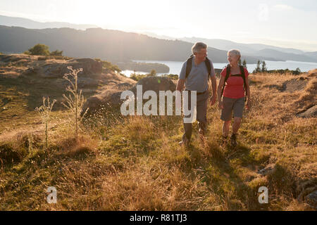 Senior Paar auf dem Hügel auf der Wanderung durch die Landschaft im Lake District in Großbritannien Stockfoto