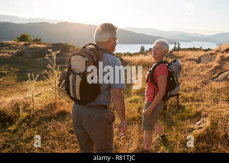 Senior Paar auf dem Hügel auf der Wanderung durch die Landschaft im Lake District in Großbritannien Stockfoto