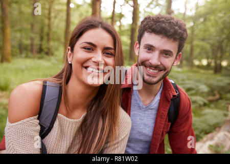 Eine junge Paare auf die Kamera während einer Wanderung im Wald, Lächeln, Porträt schließen Stockfoto