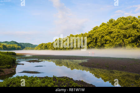 Paar in Ihrem kleinen Boot auf die Kleine Tennessee River als Morgendämmerung Nebel Aufzüge im Morgengrauen in der Nähe von Gatlinburg, Tennessee, USA. Stockfoto