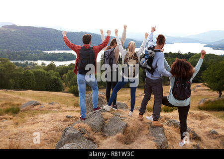 Eine Gruppe von fünf jungen Erwachsenen Freunde feiern auf dem Gipfel ankommen, nach einer Wanderung, Rückansicht Stockfoto