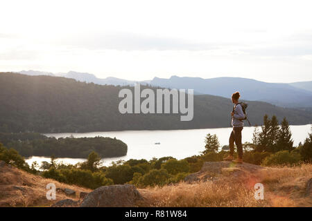 Ein junger gemischter Rasse Mensch allein stehend auf dem Rock, Seeblick, Landschaft Stockfoto