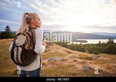Ein junger Erwachsener kaukasische Frau allein stehend auf dem Hügel bei Wandern, bewundern, Ansicht von hinten Stockfoto