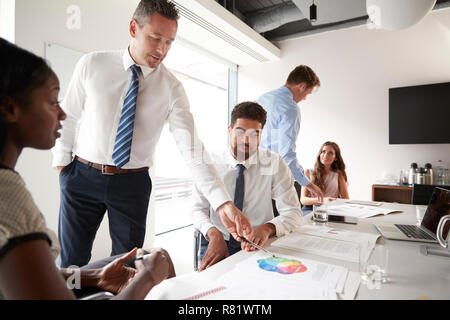 Unternehmer und Unternehmerinnen, um den Tisch in der modernen Sitzungssaal Stockfoto