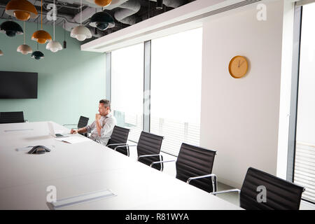 Leger gekleidet Reife Geschäftsmanns, der auf dem Laptop am Konferenztisch im Tagungsraum Stockfoto