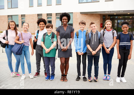 Portrait von lächelnden High School Student Group mit weiblichen Lehrer außerhalb der Schule Gebäude Stockfoto