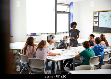 Weibliche High School Tutor steht die Tabelle mit Studenten Lehre Lektion Stockfoto