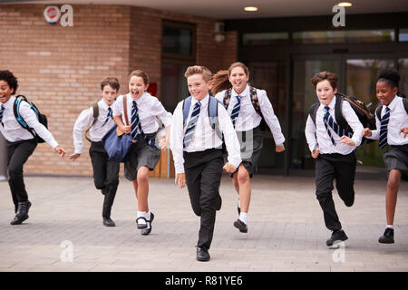 Gruppe von Schülerinnen und Schüler tragen Uniform der Schulgebäude in Richtung Kamera am Ende der Klasse Stockfoto