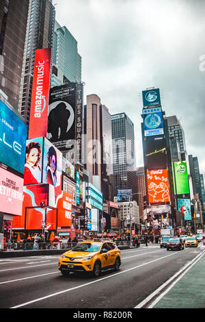 New York City, USA - 28.November 2018: Typische Straßenszene in Times Square, NEW YORK CITY, mit Yellow Cab Taxi und hellen Lichter der Anzeigen, die auf hohen Gebäuden Stockfoto