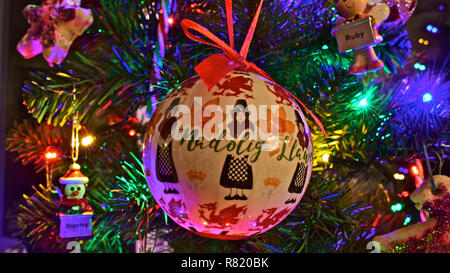 Bunten Christbaumschmuck, eines mit einem Waliser Dame in traditionellen constume und die Worte "Nadolig Llawen" - (Frohe Weihnachten in Walisisch) Stockfoto