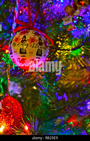 Bunten Christbaumschmuck, eines mit einem Waliser Dame in traditionellen constume und die Worte "Nadolig Llawen" - (Frohe Weihnachten in Walisisch) Stockfoto