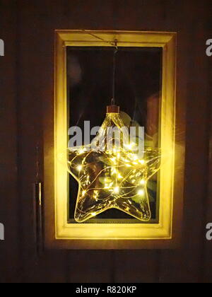 Beleuchtete sternförmigen Weihnachten Dekoration in kleinen Fenster Stockfoto