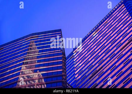 Abstrakte Gebäude bei Nacht, geometrische Muster aus Glas und Beton, Hochhaus, Design mit Reflexion. Städtische Gebäude Hintergrund Stockfoto