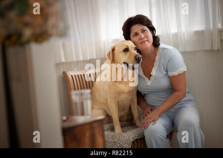 Besorgt reife Frau sitzt mit ihrem Hund. Stockfoto