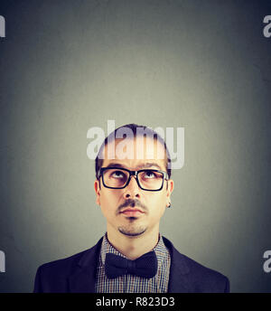 Nach bärtigen Mann in Gläsern, die Betrachtung auf grauem Hintergrund Stockfoto