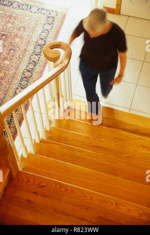 Reife Frau zu Fuß die Treppen im Haus, USA Stockfoto